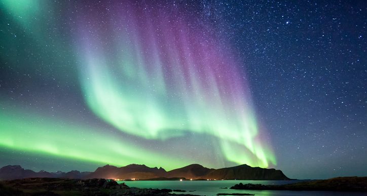 Northern lights over water. Header image for Cambridge IGCSE™ Combined and Co-ordinated Sciences blog post.